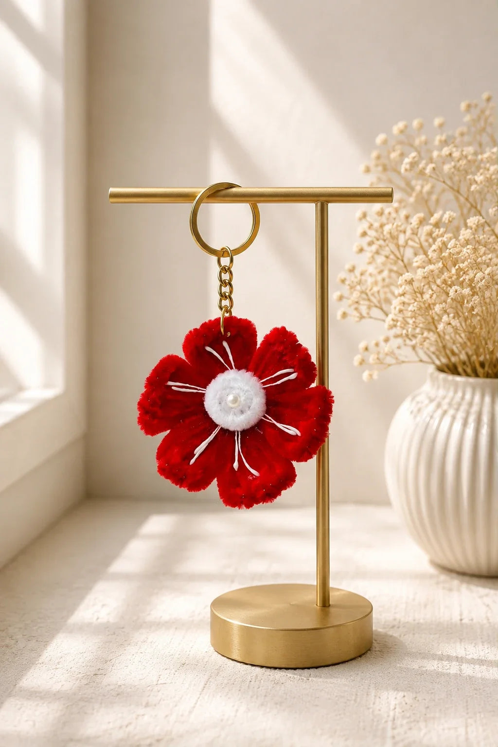 Red poppy keychain hanging on a canvas tote bag handle